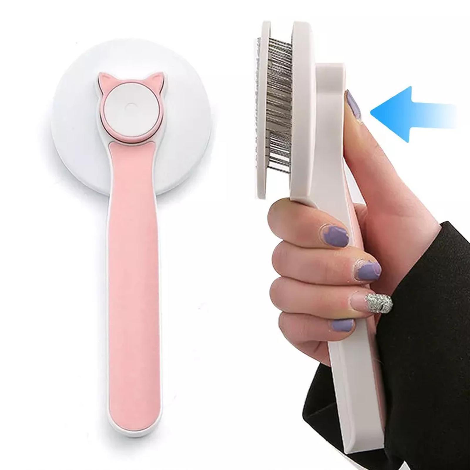 Pet grooming tool with pink handle and white head, held by a hand.
